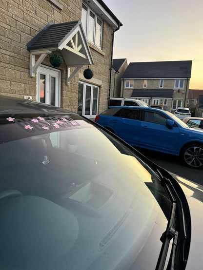 Black Obsessed cherry blossom windscreen banner fitted to a grey car