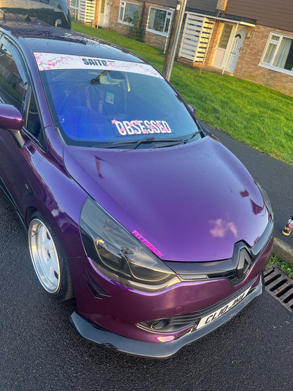 Angled view of purple Renault Clio with white Obsessed cherry blossom windscreen banner