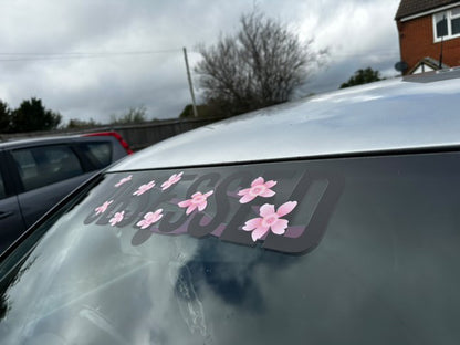 Side view of black Obsessed cherry blossom windscreen banner on a silver car