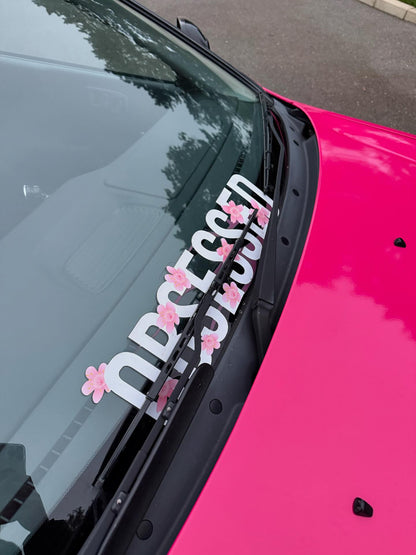 White Obsessed cherry blossom windscreen banner fitted along the lower windscreen of a pink car