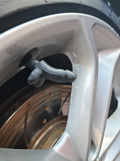 Grey 3D printed novelty tyre valve cap fitted to a silver alloy wheel